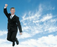 A businessman jumping into the clouds