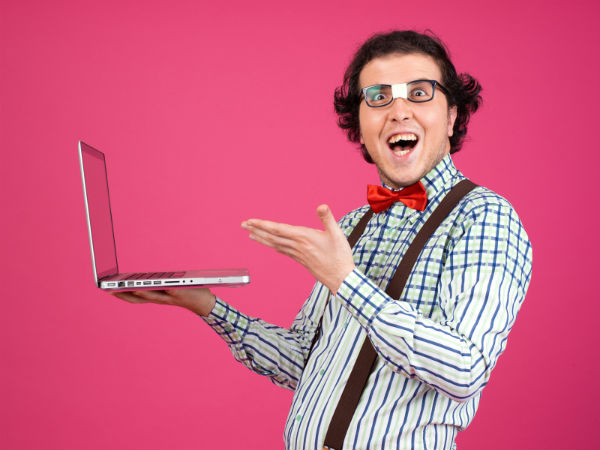 Nerd in suspenders holding a laptop