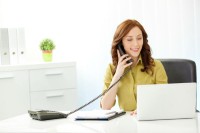 Businesswoman on the phone in front of a laptop