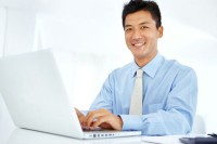Asian man on his white laptop