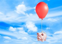 Piggybank flying with a balloon in the sky