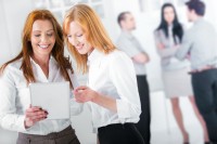 Two businesswomen using tablet PC