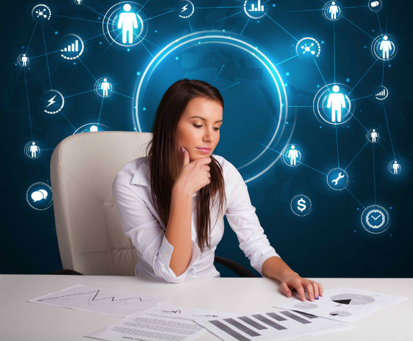 Woman at her desk looking at charts surrounded by social media icons