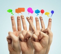 Fingers with faces and thought bubbles representing social media