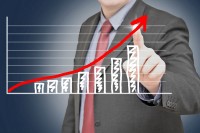 Man in suit leading a bar graph upwards